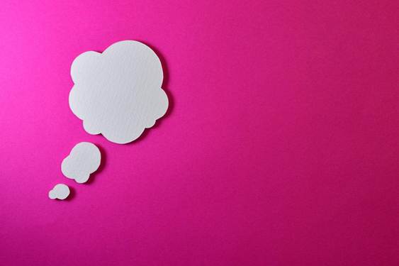 A white thought bubble on a vibrant pink background, symbolizing the concept of thoughts and ideas.