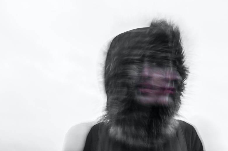 A blurry image of a person wearing a hood, suggesting a sense of confusion or emotional turmoil.